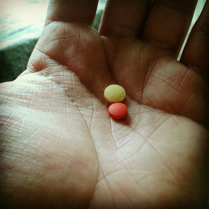 Two painkiller tablets in an open palm