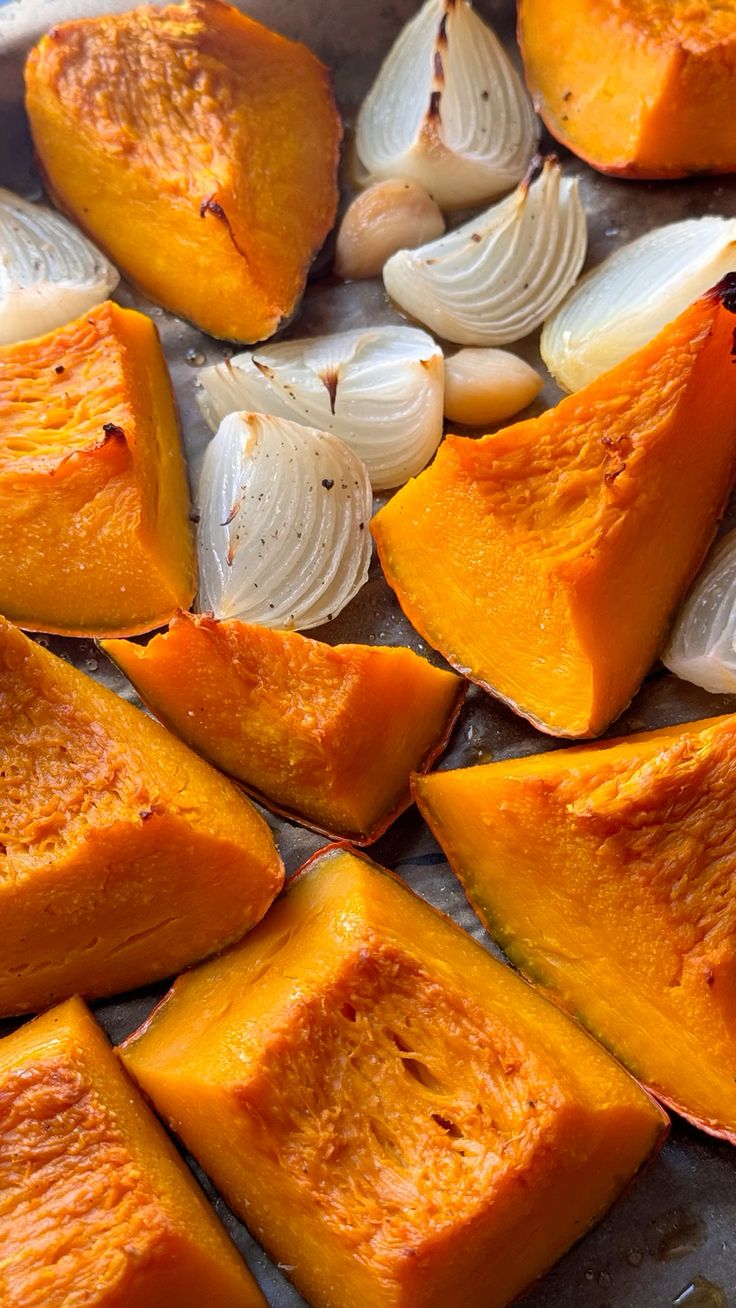 Roasted pumpkin with onion and garlic on a baking tray