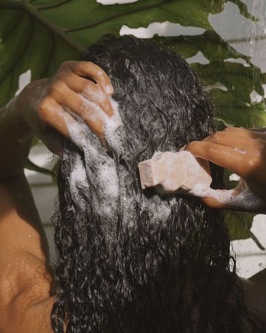 Washing long hair with foam in the shower